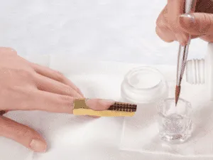 Applicazione acrilico su unghia con cartina per la ricostruzione professionale.