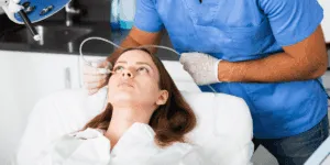 Paziente distesa durante un trattamento di carbossiterapia viso per migliorare l'elasticità cutanea e il tono.