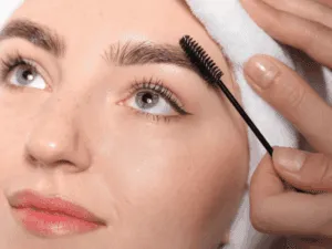 Donna che utilizza uno scovolino per mostrare come funzionano le extension sopracciglia garantendo un aspetto ordinato e naturale
