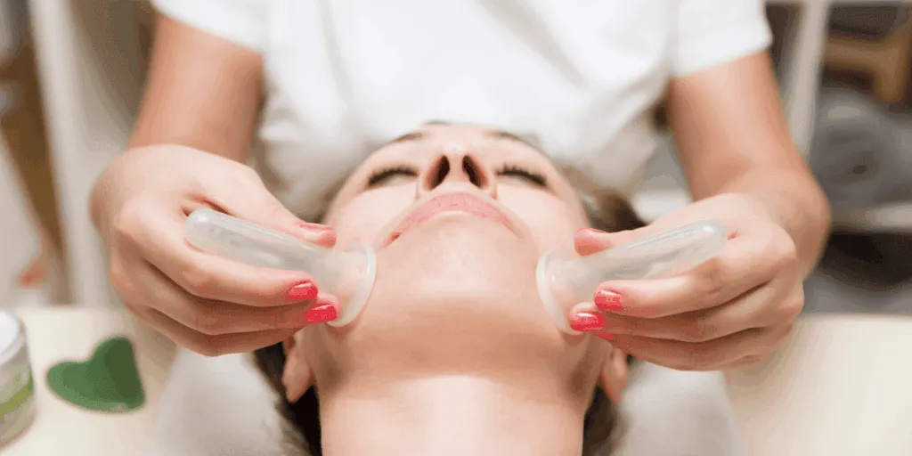 Trattamento di coppettazione viso in centro estetico, con coppette in silicone applicate per stimolare microcircolazione e tono della pelle.