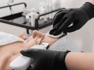Pulizia profonda della zona T con dispositivo ultrasuoni viso. Applicazione del dispositivo ultrasuoni viso per il trattamento dei punti neri sulla fronte.