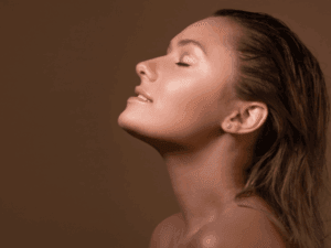 Primo piano di una donna con un'abbronzatura ambrata e uniforme ottenuta con doccia solare a bassa pressione.