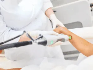 Depilazione alessandrite Operatrice che effettua un trattamento di epilazione laser alessandrite sull’avambraccio di una cliente.
