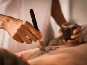 Applicazione di maschera esfoliante sul corpo con pennello in cabina estetica