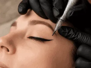 Eyeliner grafico semipermanente definito con codina precisa durante un trattamento di dermopigmentazione occhi.