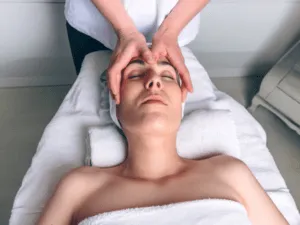 Tecnica di massaggio Kobido, con il viso disteso e le mani che eseguono un movimento specifico sulla fronte e sulle guance.