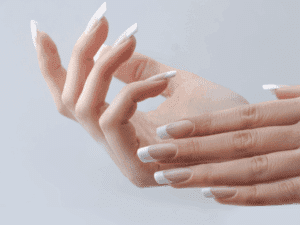 Mani femminili con unghie lunghe e french manicure bianca su base neutra.