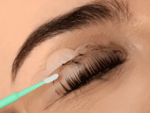 Trattamento laminazione ciglia – applicazione prodotto professionale Applicazione del prodotto per la laminazione ciglia durante il trattamento professionale, con ciglia sollevate su bigodino in silicone.