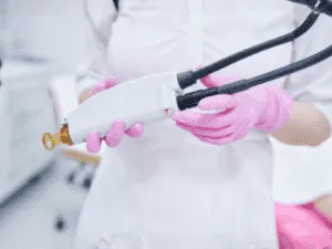 Manipolo laser alessandrite pronto per il trattamento Operatrice estetica con guanti rosa che prepara il manipolo del laser alessandrite per un trattamento di epilazione.