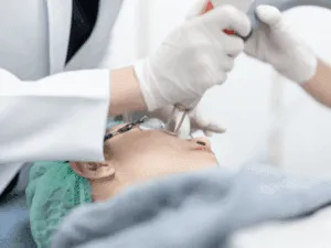 Professionista che applica trattamento laser su viso di paziente per ridurre le macchie cutanee