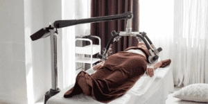 Persona sdraiata su lettino estetico durante trattamento corpo con macchina laser yag professionale in un centro estetico
