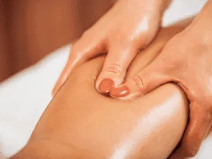 Massaggio linfodrenante gambe per ridurre gonfiore e cellulite Primo piano di un massaggio linfodrenante sulla coscia, con movimenti lenti e ritmici tipici del linodrenaggio gambe, trattamento drenante linfatico utile contro cellulite e gonfiore.