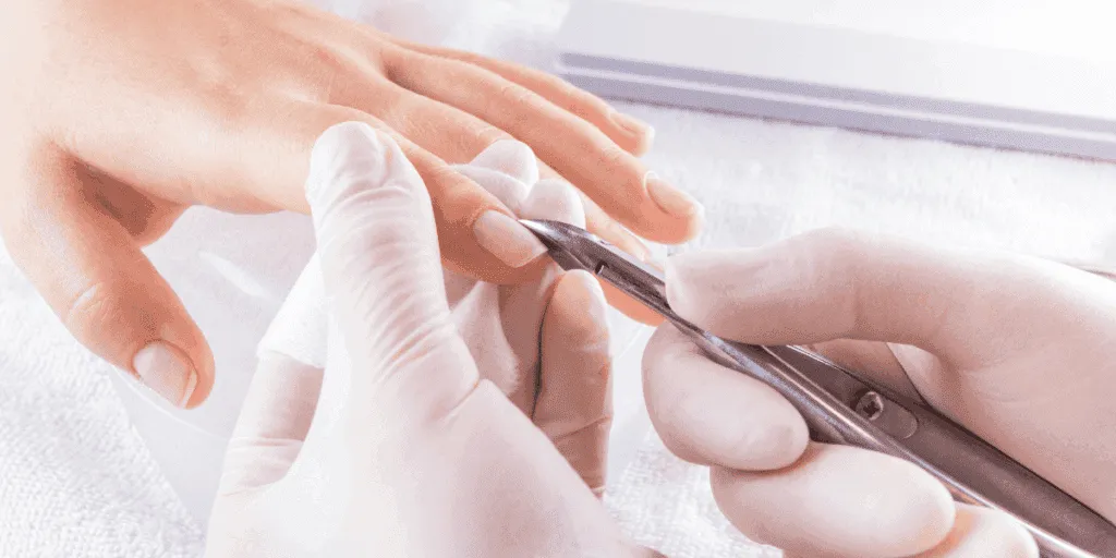 Manicure estetica professionale con estetista che rimuove delicatamente le cuticole usando strumenti sterilizzati.
