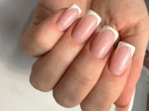 Unghie squadrate con french manicure rosa e punta bianca ad alta definizione.