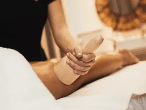 Utilizzo di massaggiatore manuale anticellulite sulla gamba per stimolare il drenaggio