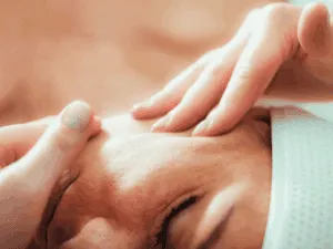 Massaggio lifting eseguito su una donna, concentrandosi su guance e collo per distendere e tonificare la pelle.