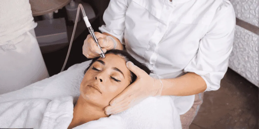 Trattamento di microdermoabrasione viso con punta di diamante eseguito da estetista professionista per levigare la pelle e ridurre cicatrici e macchie.