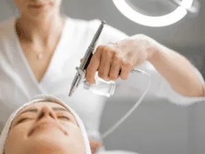Ossigeno terapia viso con aerografo professionale durante un trattamento ossigenazione viso non invasivo.
