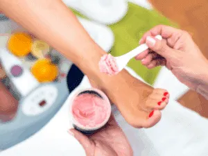 Applicazione di scrub e maschera nutriente durante una pedicure spa professionale.