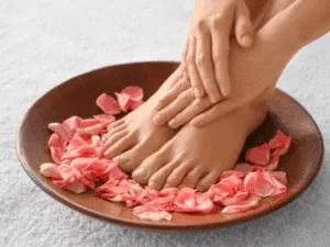 Piedi curati circondati da petali di rosa dopo una pedicure dry professionale.