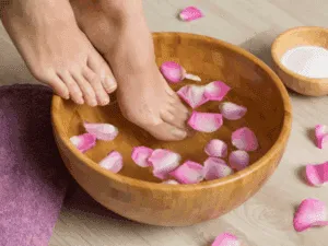 Pediluvio con petali di rosa durante una pedicure spa rilassante.