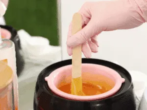 Preparazione della ceretta a caldo in pentolino per una depilazione professionale.