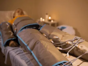 Pressoterapia estetica professionale Donna sdraiata sul lettino durante una seduta di pressoterapia estetica professionale con gambali ad aria compressa per migliorare il microcircolo e i benefici della pressoterapia alle gambe.