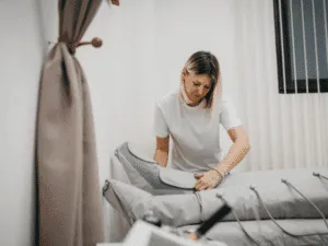 Pressoterapia e dimagrimento Estetista che prepara i gambali per una seduta di pressoterapia, mostrando come funziona il trattamento e come si svolgono le sedute di pressoterapia estetica professionale.