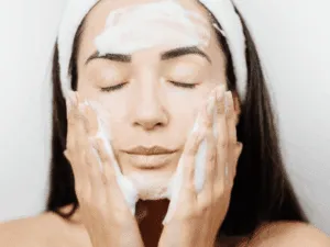primo step pulizia del viso fai da te detersione del viso con schiuma detergente durante pulizia fai da te