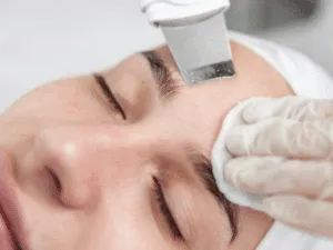 Ultrasuoni su viso Esfoliazione del viso con spatola a ultrasuoni durante trattamento estetico senza spremitura.