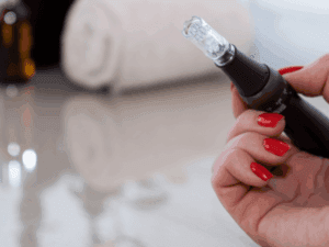 Seduta professionale di microneedling Dispositivo dermapen utilizzato durante una seduta di microneedling professionale