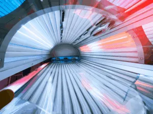 Vista interna di un lettino solare a bassa pressione con lampade accese e sistema di ventilazione integrato.