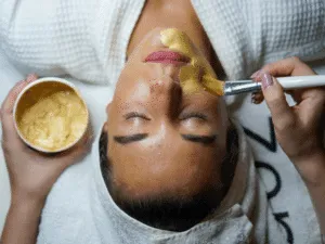 step finale pulizia del viso Trattamento viso con applicazione di maschera dorata nutritiva mediante pennello in centro estetico.