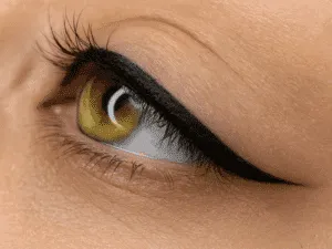 Close-up di un eyeliner grafico permanente realizzato con tecnica PMU su occhio verde, linea definita e codina sottile.