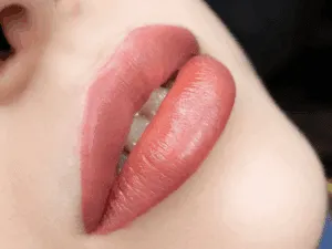 Primo piano di labbra appena pigmentate con la tecnica del lip blush, dal colore rosato naturale e contorni definiti.