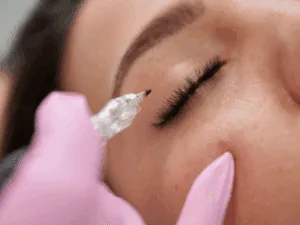 Trattamento di trucco permanente agli occhi con dermografo e occhio chiuso della cliente.