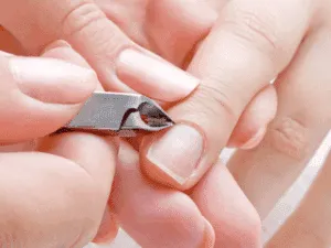 Rimozione professionale delle cuticole con tronchesina durante una manicure curativa