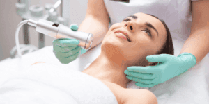 Donna durante trattamento vacuum viso professionale, eseguito con dispositivo estetico a micro-aspirazione per migliorare tono e luminosità della pelle.