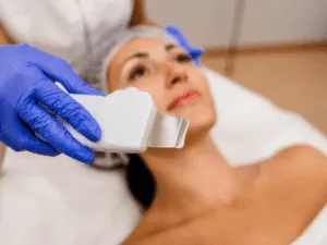 pulizia ultrasuoni toglie punti neri Apparecchiatura professionale per pulizia ad ultrasuoni del viso con operatore dotato di guanti.
