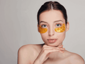 Donna con patch illuminanti per preparare l’area al camouflage occhiaie e ai trattamenti di trucco permanente per coprirle