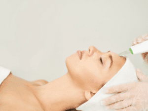 trattamento skin scrubber ultrasuoni Donna durante una pulizia del viso a ultrasuoni con skin scrubber utilizzato in modalità peeling sonico.